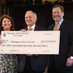 Picture of two class co-chairs presenting a class check to W&L president during reunion weekend in Lee Chapel.