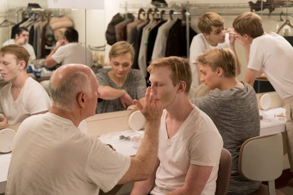 Director Rob Mish shows Mike Bracey &#039;20 how to use makeup to transform himself into Lurch for the 2017 production of &quot;The Addams Family: A New Musical&quot;