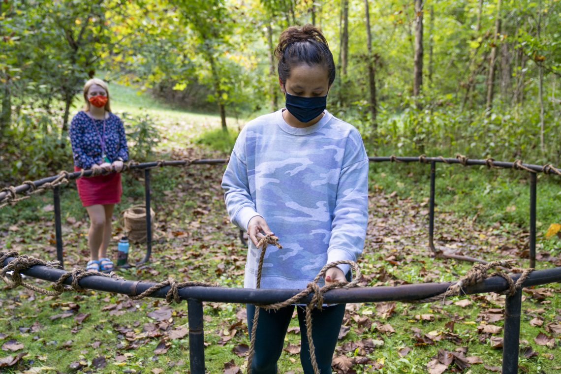Molly Pennisi &#039;24 and Reggie Zhao &#039;21 weave ropes as part of a collaborative hammock-making project in the woods behind Wilson Hall.