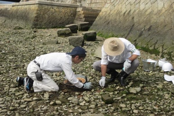 Hiroshima University researcher Reibun Kayo (left) and a colleague at the Motoyasu River in Hiroshima.