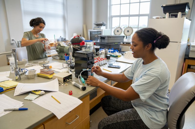 Alexandra Miyamoto &#039;23 processes plant tissue to measure carbon and nitrogen isotopes while Julienne de Vastey &#039;23 uses a C02 analyzer to measure the microbial biomass in soil taken from Yellowstone as part of the research they are doing this summer with biology professor Bill Hamilton.