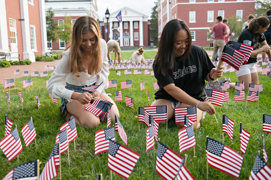 Students put out flags along Stemmons Plaza in memory of the 2,997 people who died on 9/11.