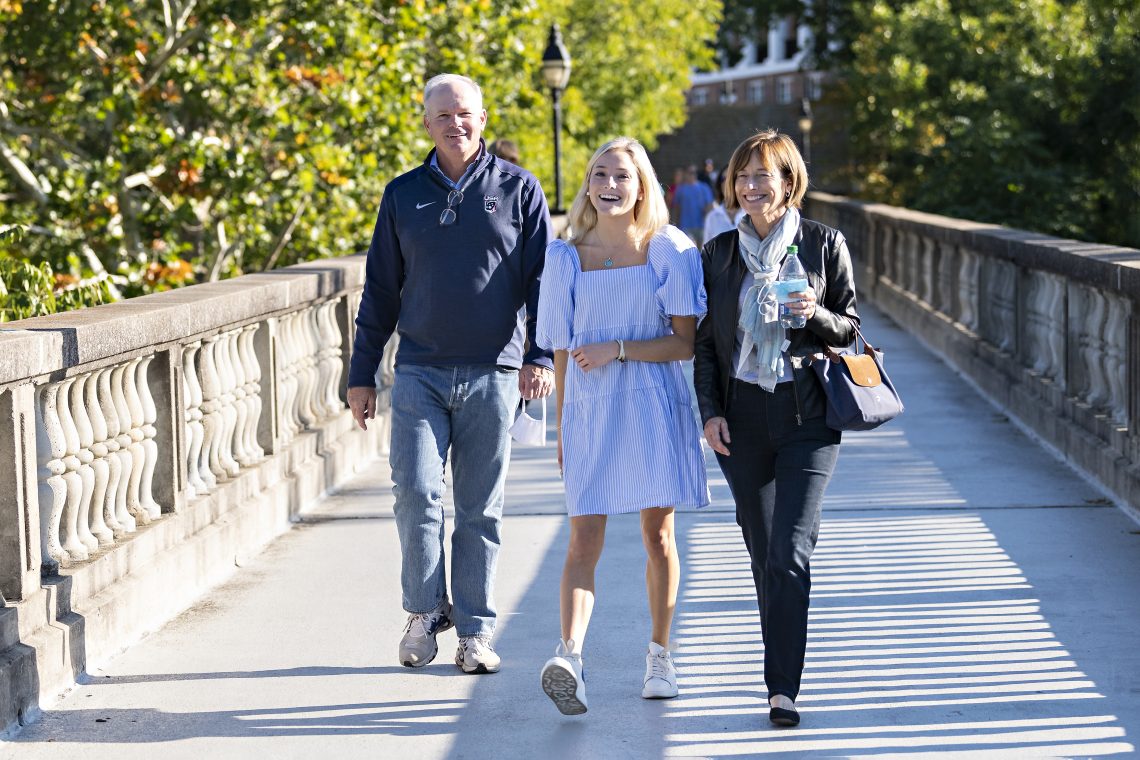 Kess Dardani &#039;24 and her parents cross the footbridge during Parents and Family Weekend.