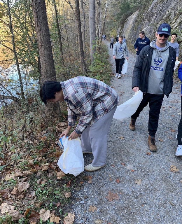 Mens lacrosse picking up litter