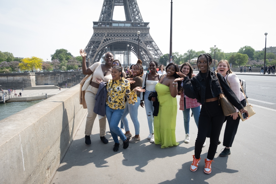 The class poses for a group photo beneath the Eiffel Tower.