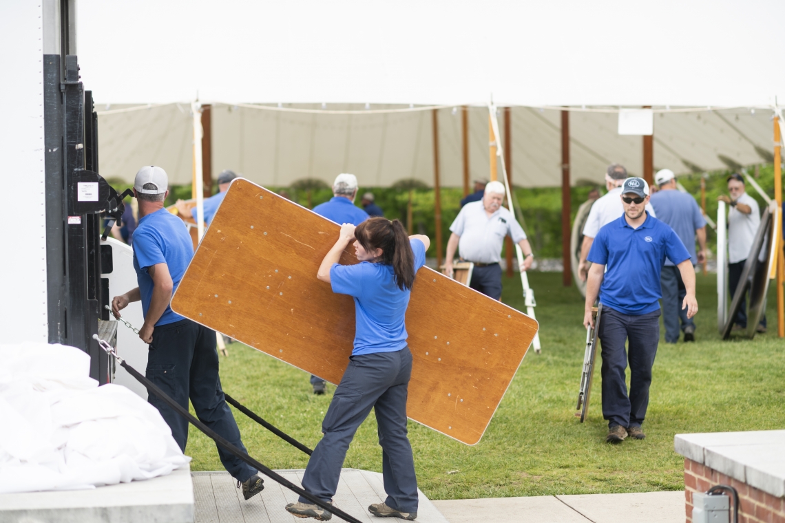 From left, foreground: Senior Electrician Ora Youngblood, Gardener Brandy Murphy and HVAC/Plumber Lucas Arthur help put away tables after a campus event.