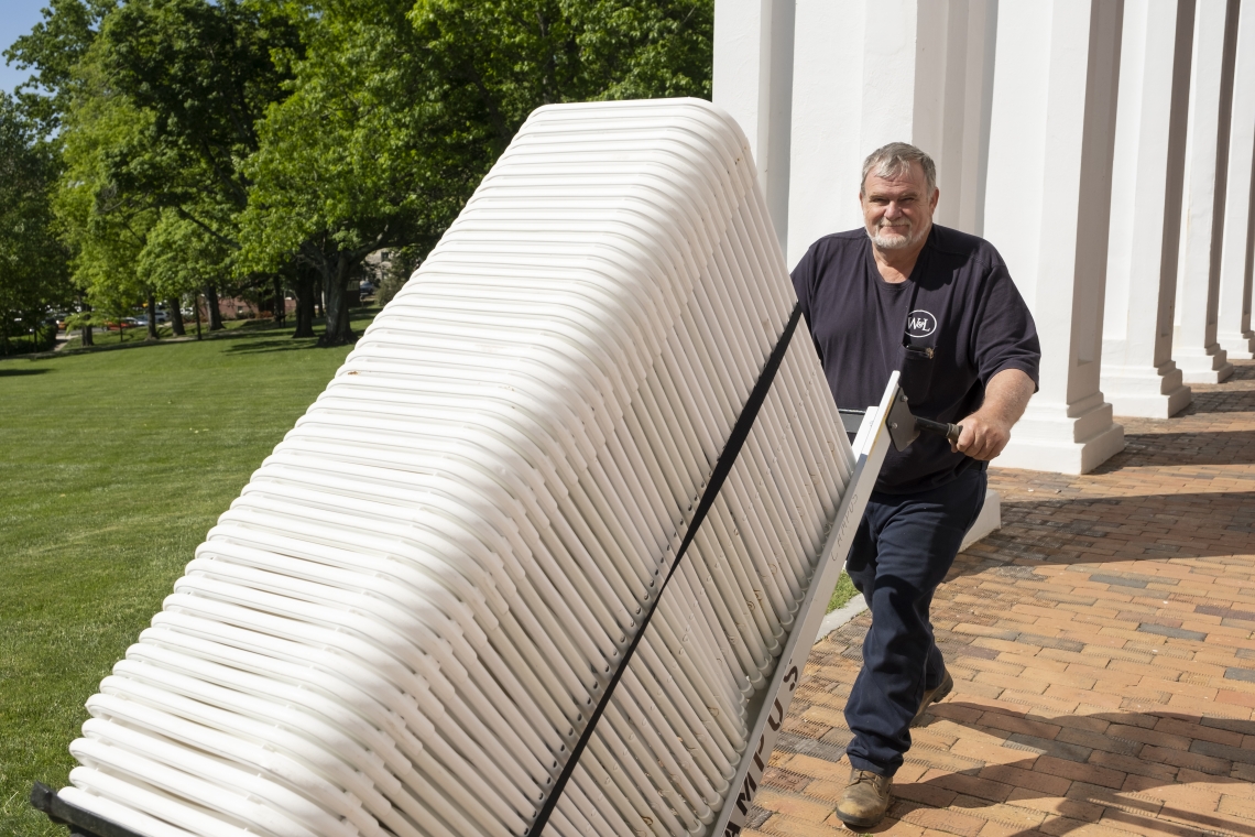 Lead Sanitation and Recycling Worker John Coffey transports chairs for Commencement set-up.