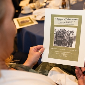 Caroline Matthews, daughter of John and Nell McDaniel, holds a copy of the cover of the forthcoming volume of the James G. Leyburn Papers in Anthropology.