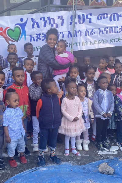 Melos Ambaye '25 poses with children involved with Amen Charitable Organization.
