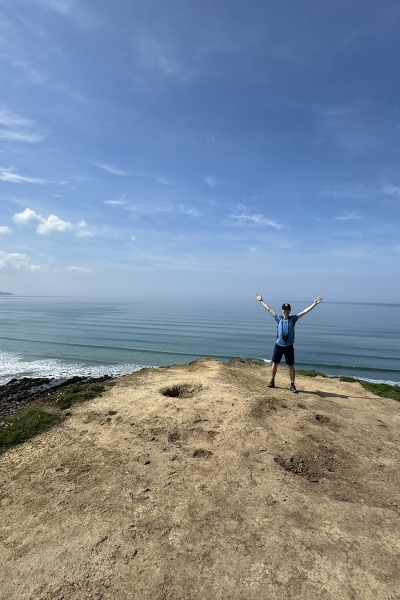 Ryan Doty '26 standing on an overlook just outside of Widemouth Bay, in Cornwall, England