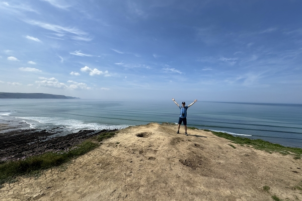 Ryan Doty '26 standing on an overlook just outside of Widemouth Bay, in Cornwall, England