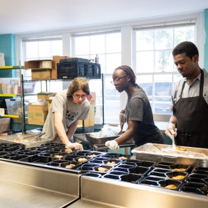 Shaliyah Rose '29 welcomes students in the Advanced Immersion and Mentoring (AIM) program to a Campus Kitchen shift.